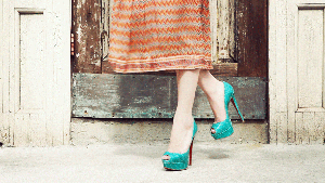 Cinemagraph of a close up of a woman's calves and feet with her dress and shadow of the dress moving
