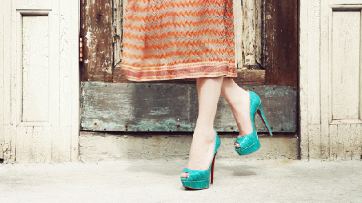 Cinemagraph of a close up of a woman's calves and feet with her dress and shadow of the dress moving
